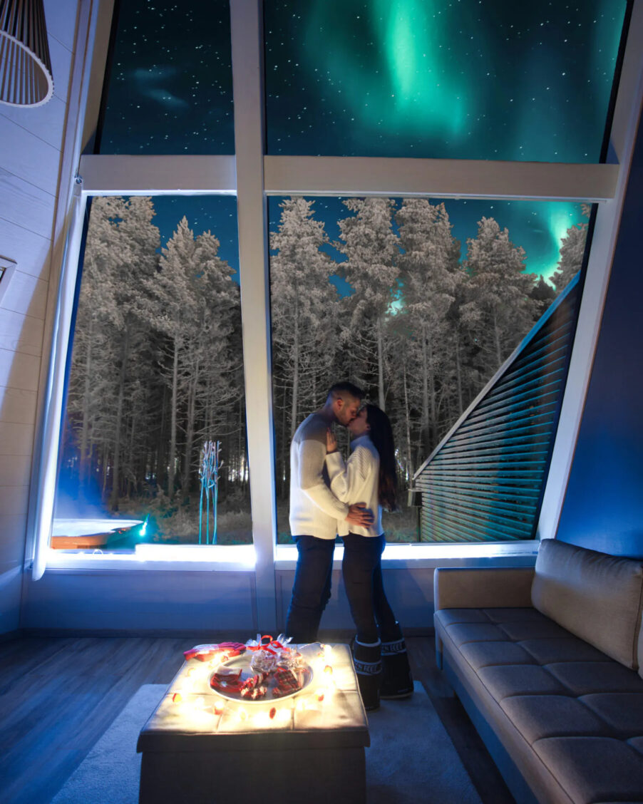 Guests enjoying northern lights above the glass resort, lapland